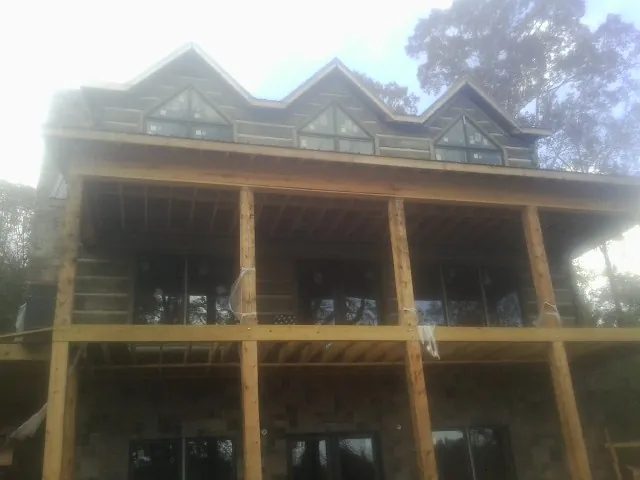 Dormers and porch framing on a large log home under construction — Roof Coating work by our crew in Hermosa Beach